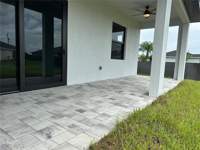 view of patio / terrace with ceiling fan and fence