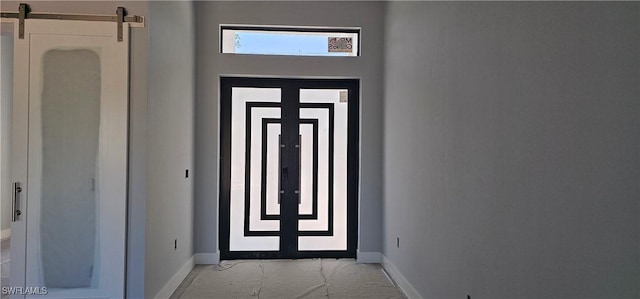 doorway with baseboards and a barn door