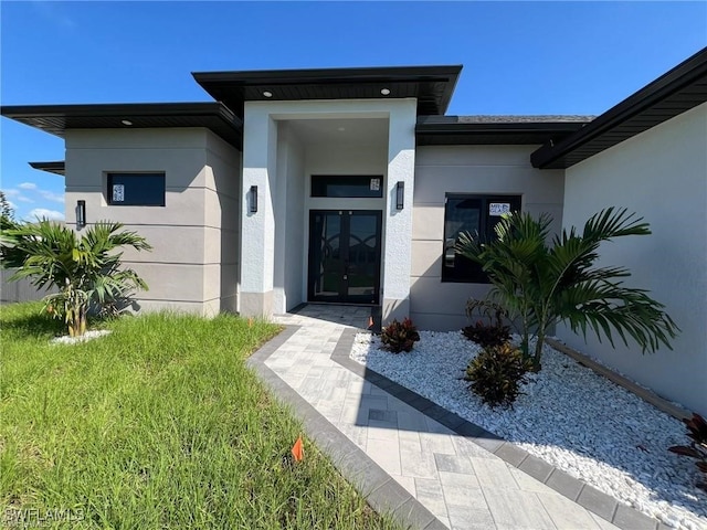 property entrance featuring french doors and stucco siding