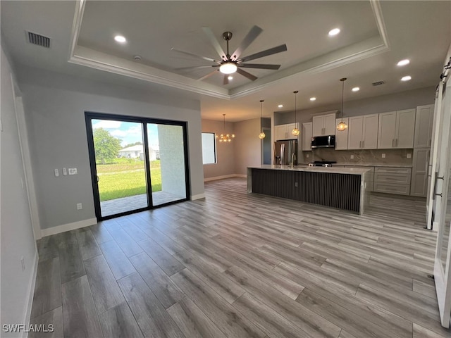 1104 Alaska Ave, Lehigh Acres, FL 33971 - kitchen featuring a raised ceiling, appliances with stainless steel finishes, open floor plan, a ceiling fan, and recessed lighting