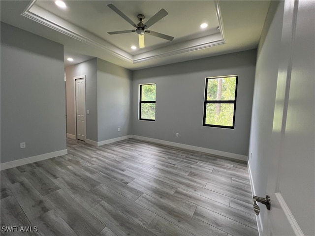 1104 Alaska Ave, Lehigh Acres, FL 33971 - spare room featuring a tray ceiling, recessed lighting, wood finished floors, ceiling fan, and ornamental molding