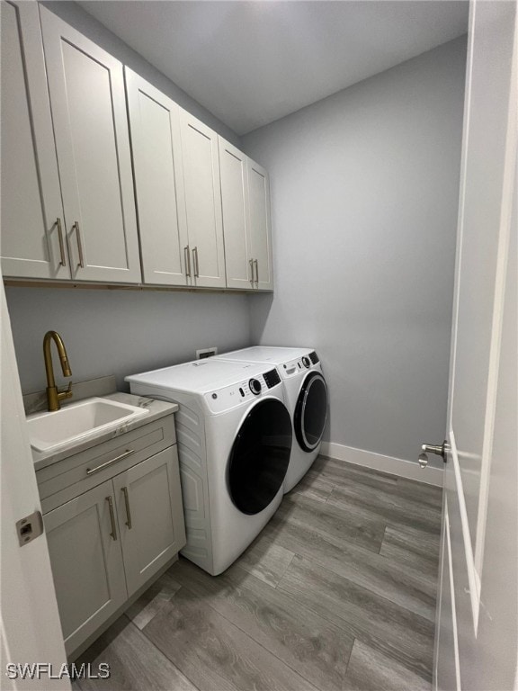1104 Alaska Ave, Lehigh Acres, FL 33971 - washroom with cabinet space, washing machine and dryer, and light wood finished floors