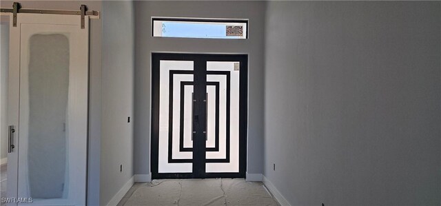 entryway with baseboards and a barn door