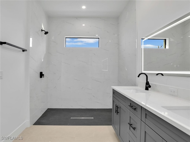 full bath with double vanity, a wealth of natural light, walk in shower, and a sink