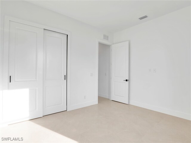 unfurnished bedroom with a closet, visible vents, and baseboards