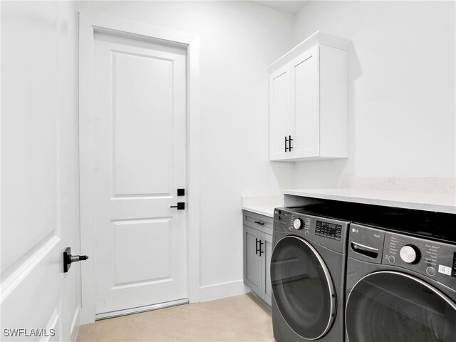 washroom with cabinet space, washer and clothes dryer, and baseboards