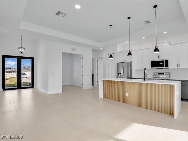 kitchen with visible vents, an island with sink, appliances with stainless steel finishes, light countertops, and recessed lighting