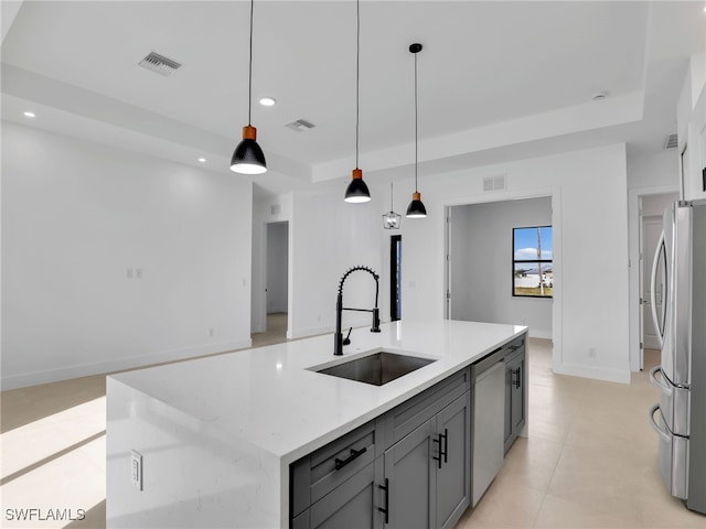 kitchen featuring a tray ceiling, stainless steel appliances, visible vents, gray cabinetry, and a sink