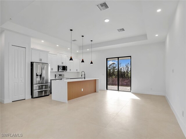 kitchen featuring recessed lighting, visible vents, open floor plan, appliances with stainless steel finishes, and a tray ceiling