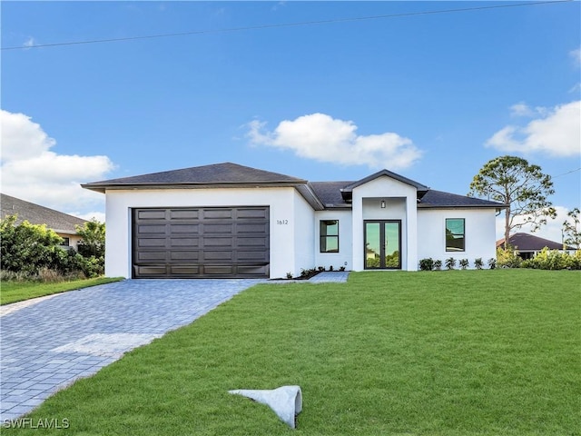 view of front of home with stucco siding, decorative driveway, french doors, a front yard, and a garage