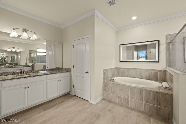 bathroom with visible vents, a garden tub, a tile shower, crown molding, and vanity