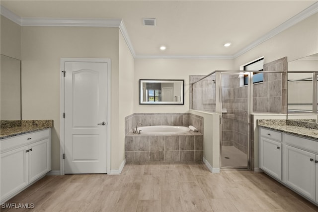 full bathroom featuring a garden tub, visible vents, ornamental molding, a stall shower, and vanity