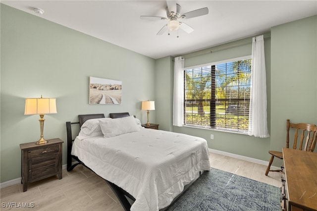 bedroom featuring light wood-style floors, baseboards, and a ceiling fan