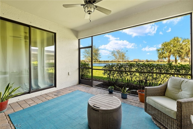 sunroom with a water view and ceiling fan