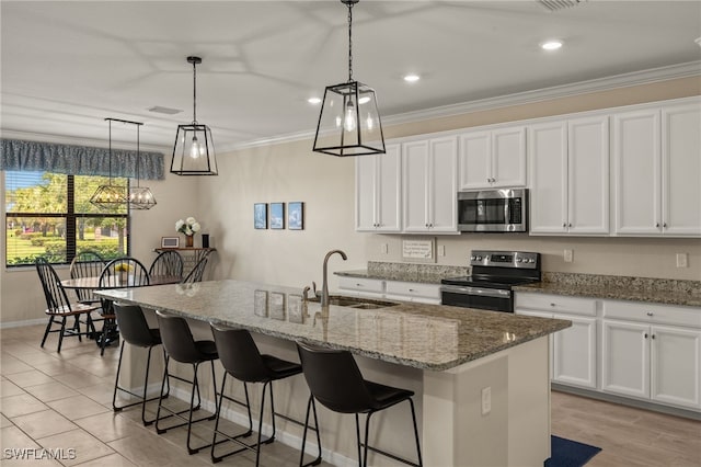 kitchen with a kitchen island with sink, stainless steel appliances, a sink, white cabinetry, and ornamental molding