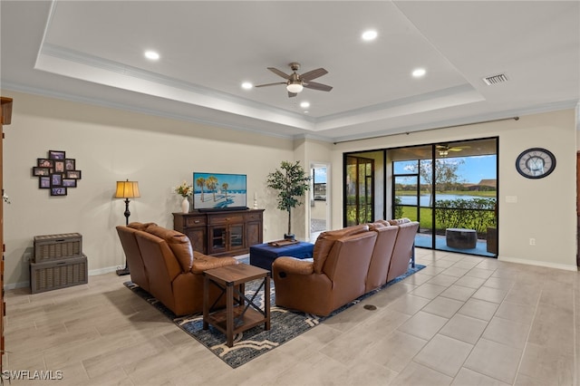 living area featuring ornamental molding, a tray ceiling, visible vents, and baseboards