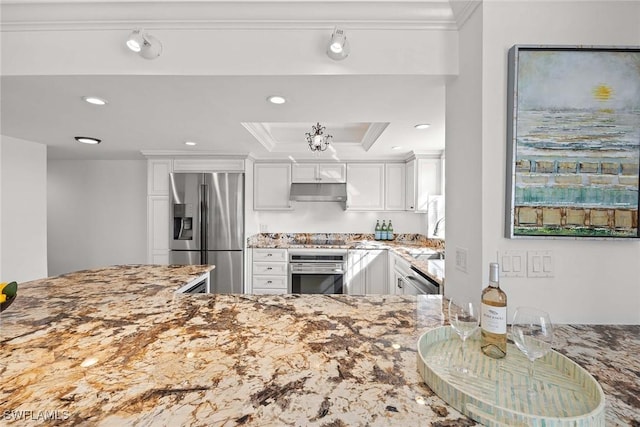 kitchen with light stone countertops, white cabinetry, under cabinet range hood, and appliances with stainless steel finishes