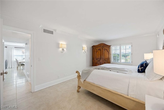 bedroom featuring ornamental molding, light tile patterned flooring, visible vents, and baseboards