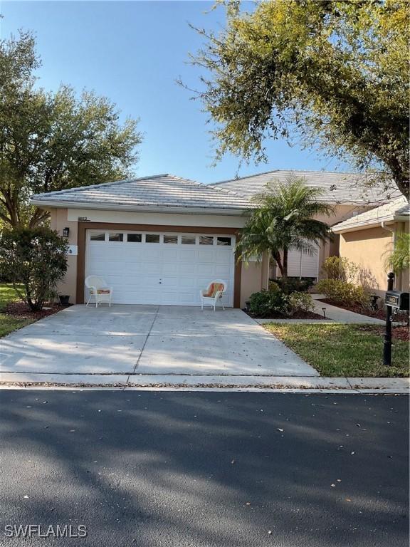 view of front of house featuring concrete driveway, an attached garage, and stucco siding