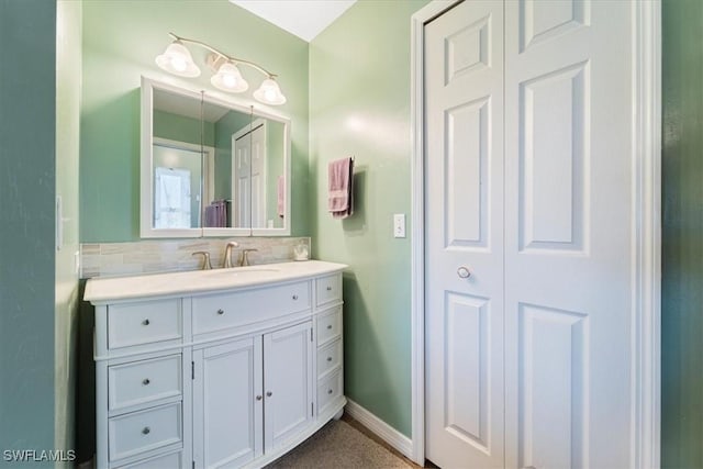 bathroom with tasteful backsplash, vanity, and baseboards