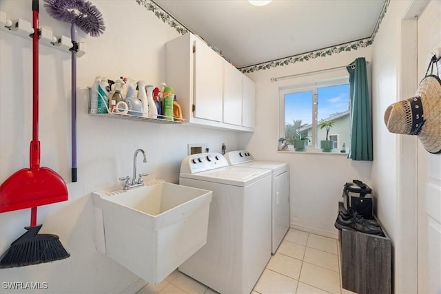 washroom featuring cabinet space, light tile patterned floors, a sink, and independent washer and dryer