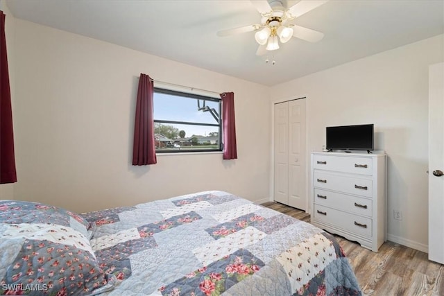 bedroom featuring a ceiling fan, light wood-type flooring, a closet, and baseboards