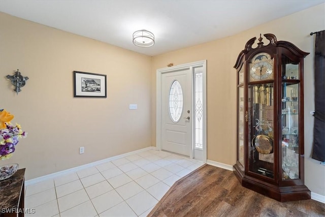 foyer featuring baseboards and tile patterned floors