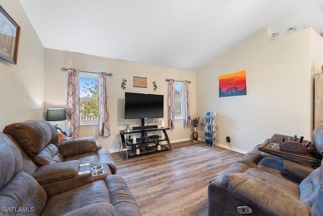 living area with lofted ceiling, wood finished floors, and baseboards