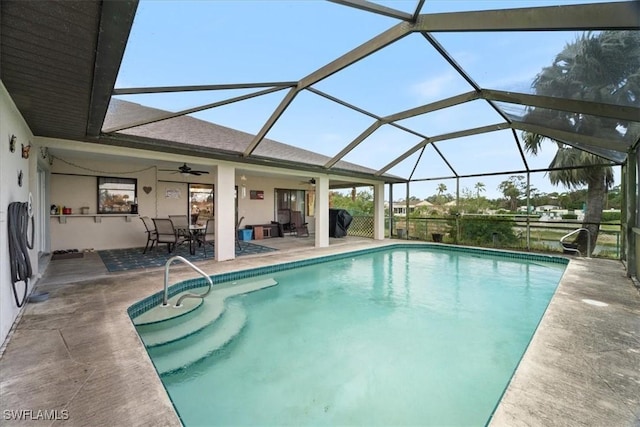 pool with a patio area, ceiling fan, and glass enclosure