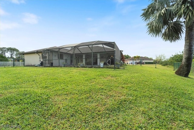 view of yard featuring glass enclosure and fence