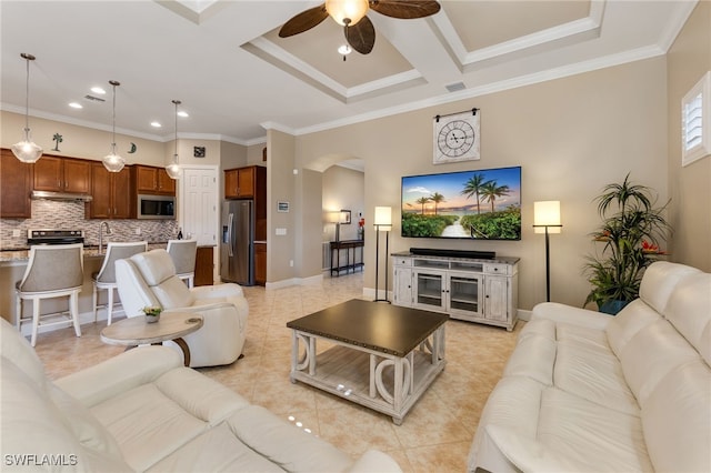 living area featuring light tile patterned floors, baseboards, arched walkways, ceiling fan, and crown molding