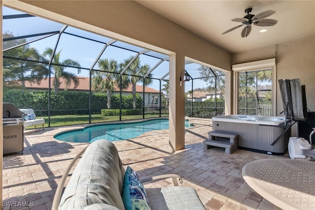 outdoor pool featuring glass enclosure, ceiling fan, a patio area, and a hot tub