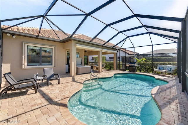 outdoor pool with glass enclosure, a patio area, and a ceiling fan