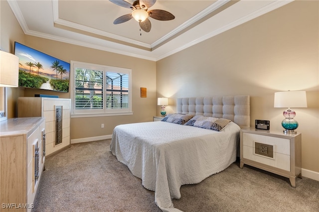 bedroom with ornamental molding, a ceiling fan, a tray ceiling, baseboards, and light colored carpet