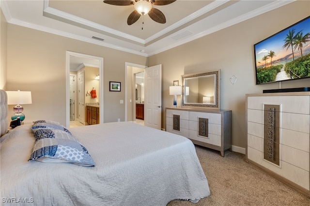 bedroom featuring a tray ceiling, visible vents, ensuite bathroom, and ornamental molding