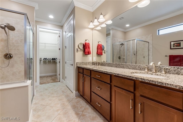 full bath with a spacious closet, ornamental molding, a stall shower, and a sink