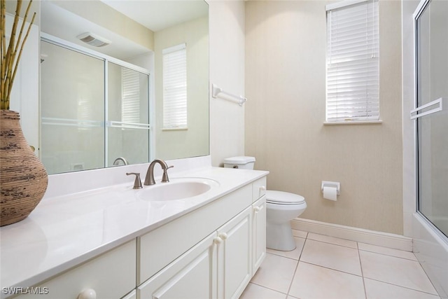 bathroom featuring tile patterned flooring, a shower with door, baseboards, toilet, and vanity