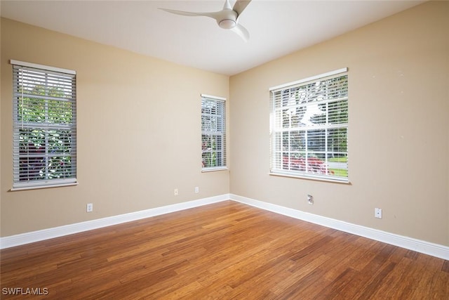 empty room featuring ceiling fan, light wood-type flooring, and baseboards