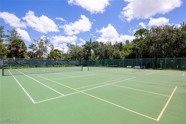 view of tennis court with community basketball court and fence