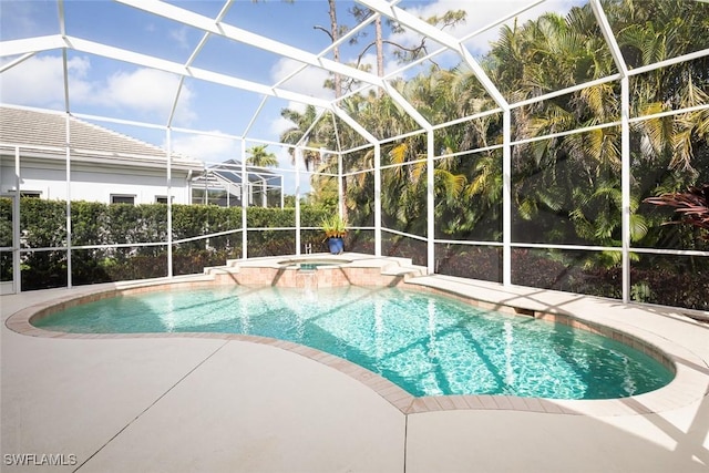 view of pool featuring glass enclosure, a patio, and a pool with connected hot tub