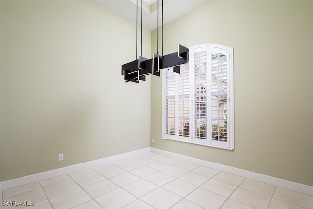 interior space with vaulted ceiling, light tile patterned floors, and baseboards