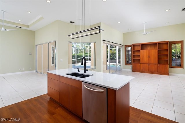 kitchen featuring open floor plan, stainless steel dishwasher, ceiling fan, and a sink