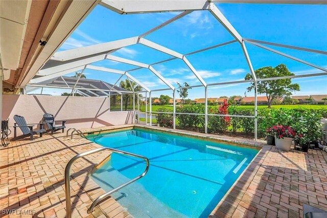 outdoor pool with glass enclosure and a patio