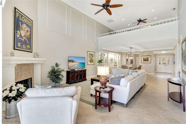 11596 Quail Village Way, Naples, FL 34119 - living room with a ceiling fan, a high ceiling, a fireplace, light tile patterned floors, and baseboards