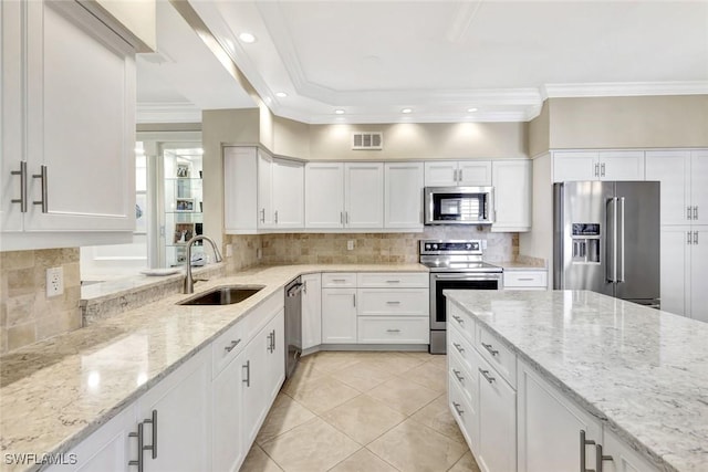 11596 Quail Village Way, Naples, FL 34119 - kitchen featuring appliances with stainless steel finishes, a sink, decorative backsplash, light tile patterned flooring, and white cabinets