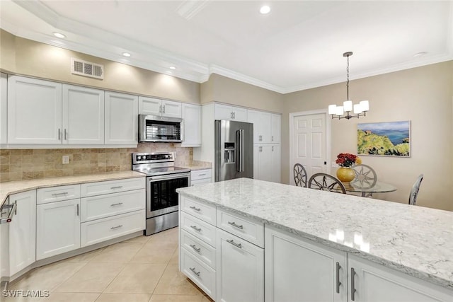 11596 Quail Village Way, Naples, FL 34119 - kitchen featuring stainless steel appliances, backsplash, a chandelier, white cabinetry, and light tile patterned flooring