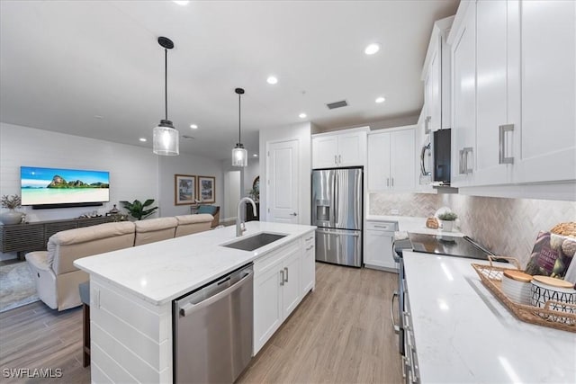 kitchen with light wood-style flooring, stainless steel appliances, a sink, visible vents, and open floor plan