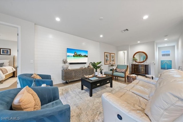 living room with light wood-style flooring, visible vents, and recessed lighting