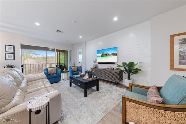 living room with light wood finished floors, visible vents, and recessed lighting