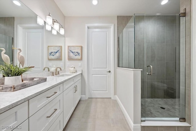 bathroom with a stall shower, vanity, and recessed lighting